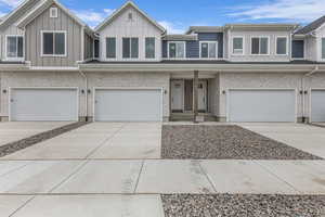 View of front of property with a garage, board and batten siding, concrete driveway, and covered porch