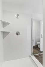 Bathroom with a shower stall and dark wood finished floors