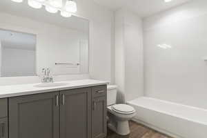 Full bath featuring vanity, light wood finished floors, and bathing tub / shower combination