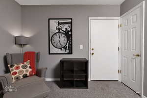 Sitting room featuring carpet flooring and baseboards