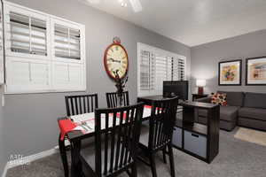 Carpeted dining room featuring baseboards and a ceiling fan