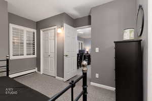 Workout room with light carpet and a baseboard radiator
