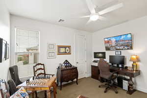 Office area with light carpet and a ceiling fan
