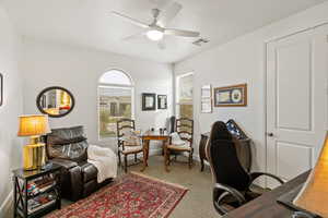 Office area featuring carpet floors and a ceiling fan