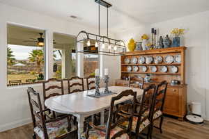 Dining space with dark wood-style floors and baseboards