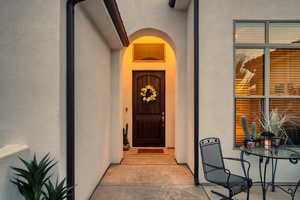 Doorway to property featuring stucco siding