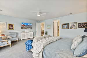 Carpeted bedroom featuring ceiling fan
