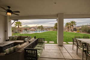 Fenced backyard with outdoor lounge area, a patio, an outdoor pool, and ceiling fan