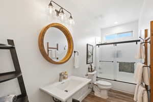 Full bathroom featuring shower / bath combination with glass door, wood finished floors, and recessed lighting