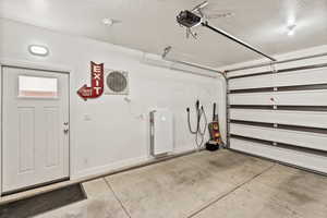 Garage featuring baseboards and a garage door opener