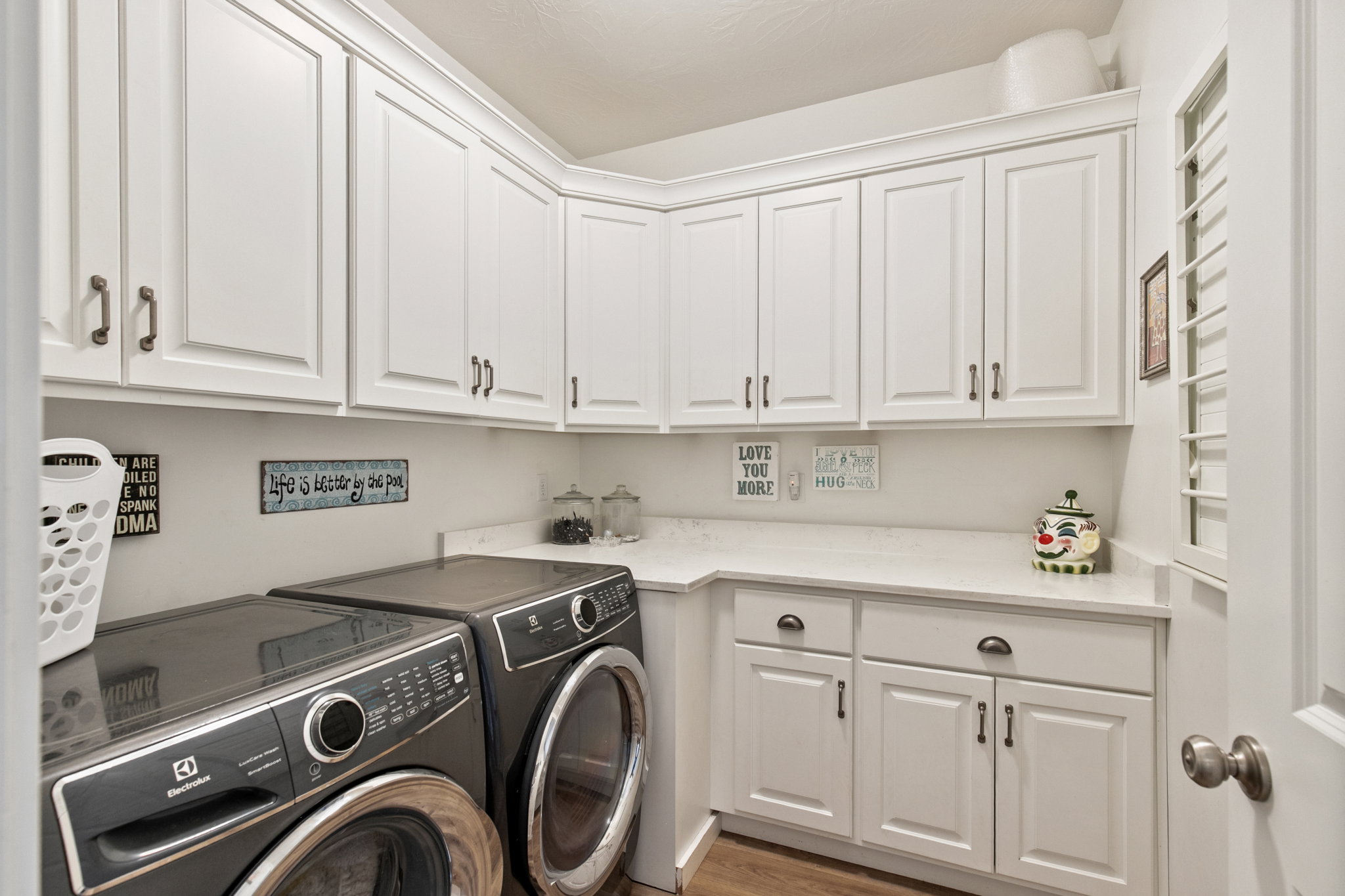 Laundry room with separate washer and dryer, wood finished floors, and cabinet space