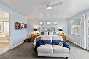 Bedroom featuring carpet flooring, a ceiling fan, ensuite bath, and access to exterior
