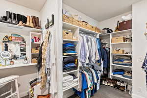 Walk in closet featuring dark colored carpet