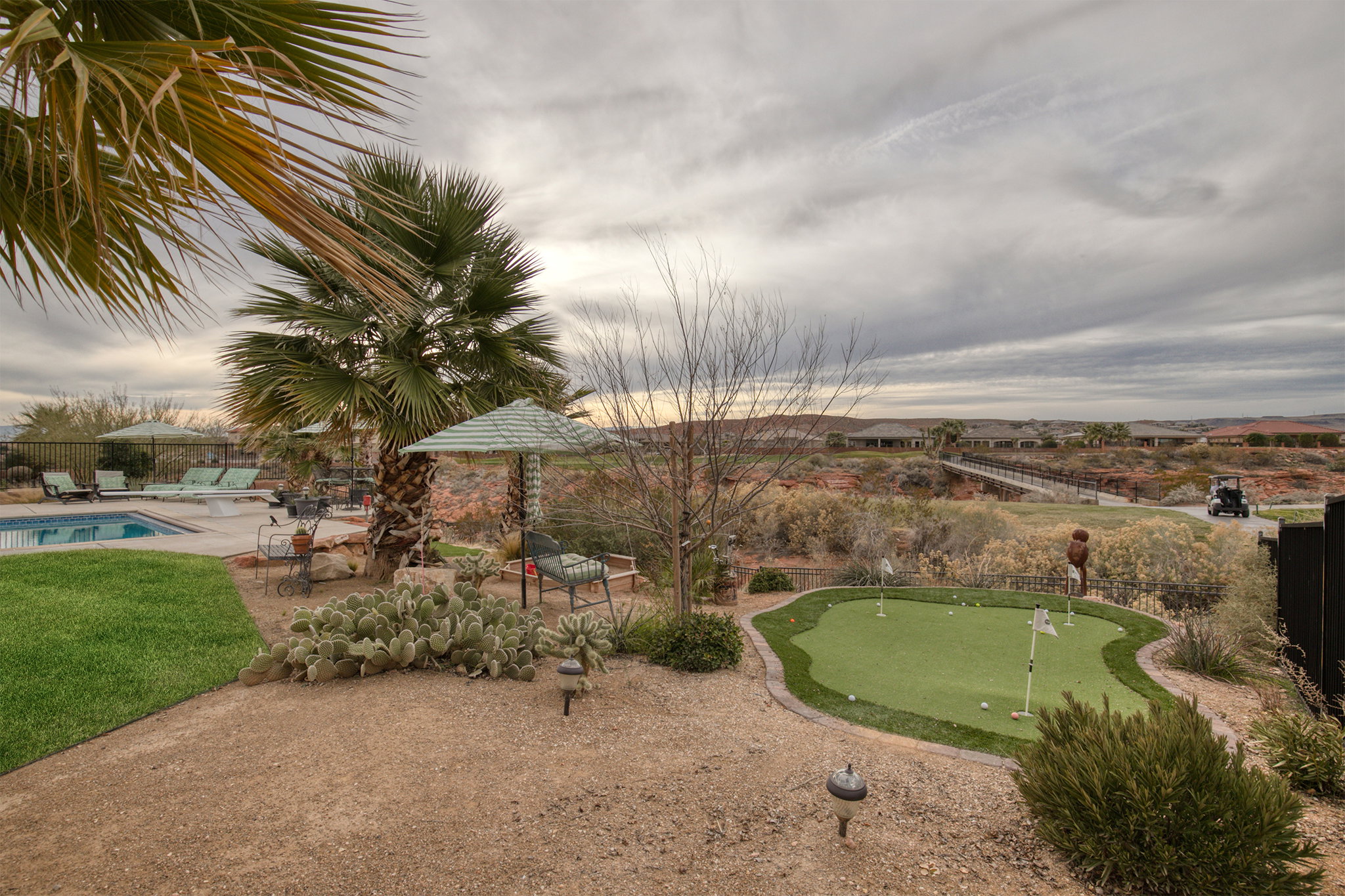 View of property's community with a patio area, a putting green, and a pool
