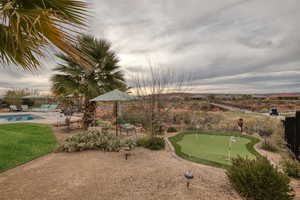 View of property's community with a patio area, a putting green, and a pool