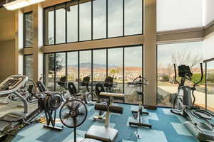 Workout area featuring a mountain view and a high ceiling