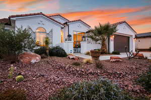 Mediterranean / spanish house featuring a tile roof, stucco siding, and a garage