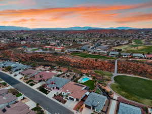 Aerial perspective of suburban area featuring a mountain backdrop and a golf course