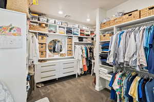 Walk in closet featuring dark colored carpet