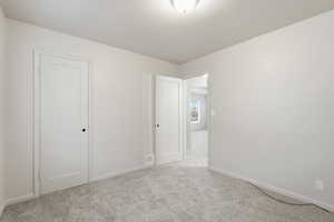 Unfurnished bedroom featuring baseboards and light colored carpet