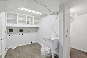 Laundry area featuring wood finished floors, washer hookup, and electric dryer hookup