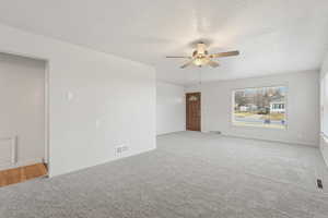 Unfurnished room with ceiling fan and light carpet