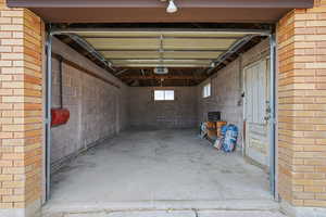 Garage featuring concrete block wall and a garage door opener