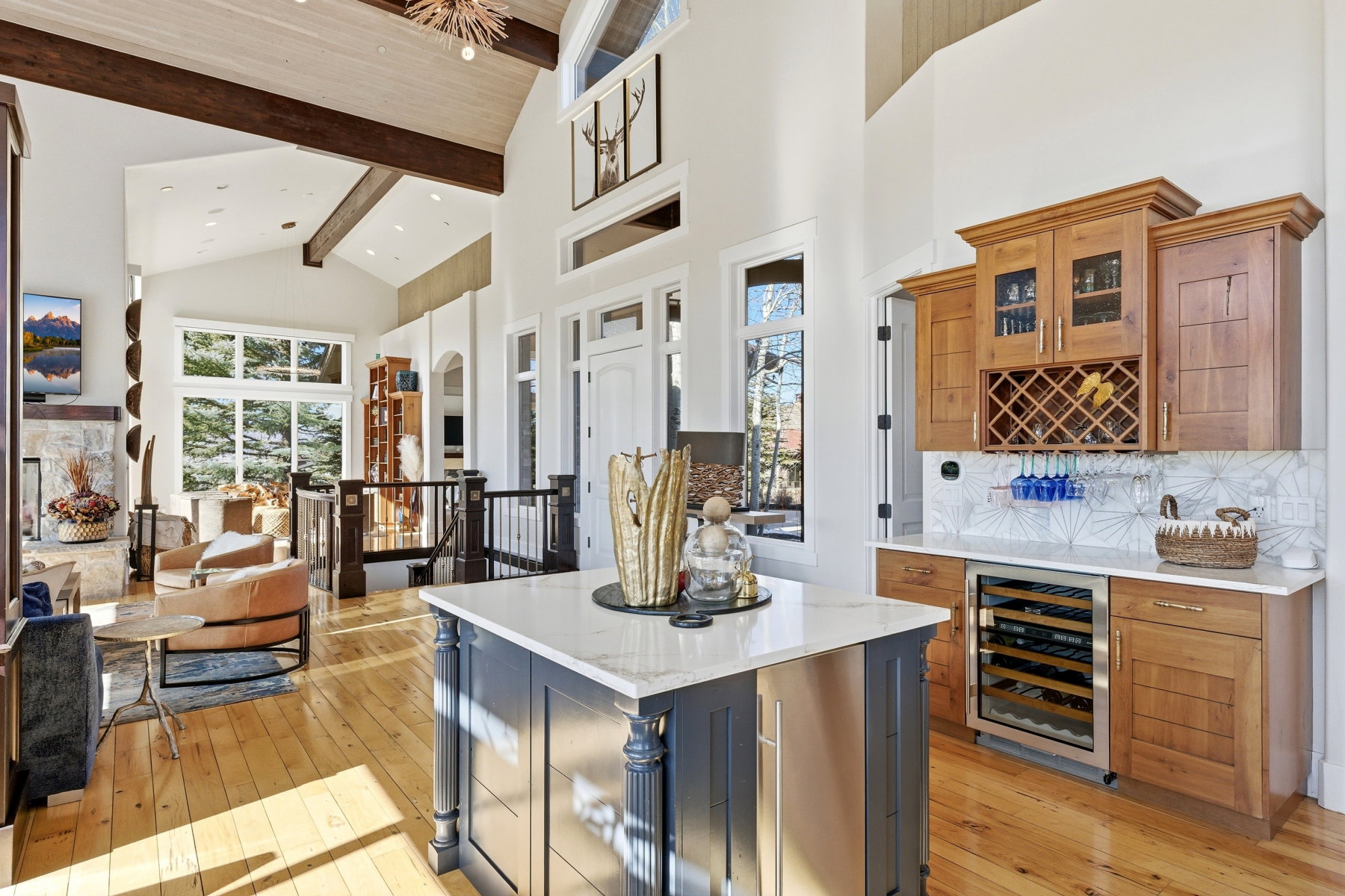 Spacious interior featuring light wood-finish flooring and a vaulted ceiling with exposed wood beams