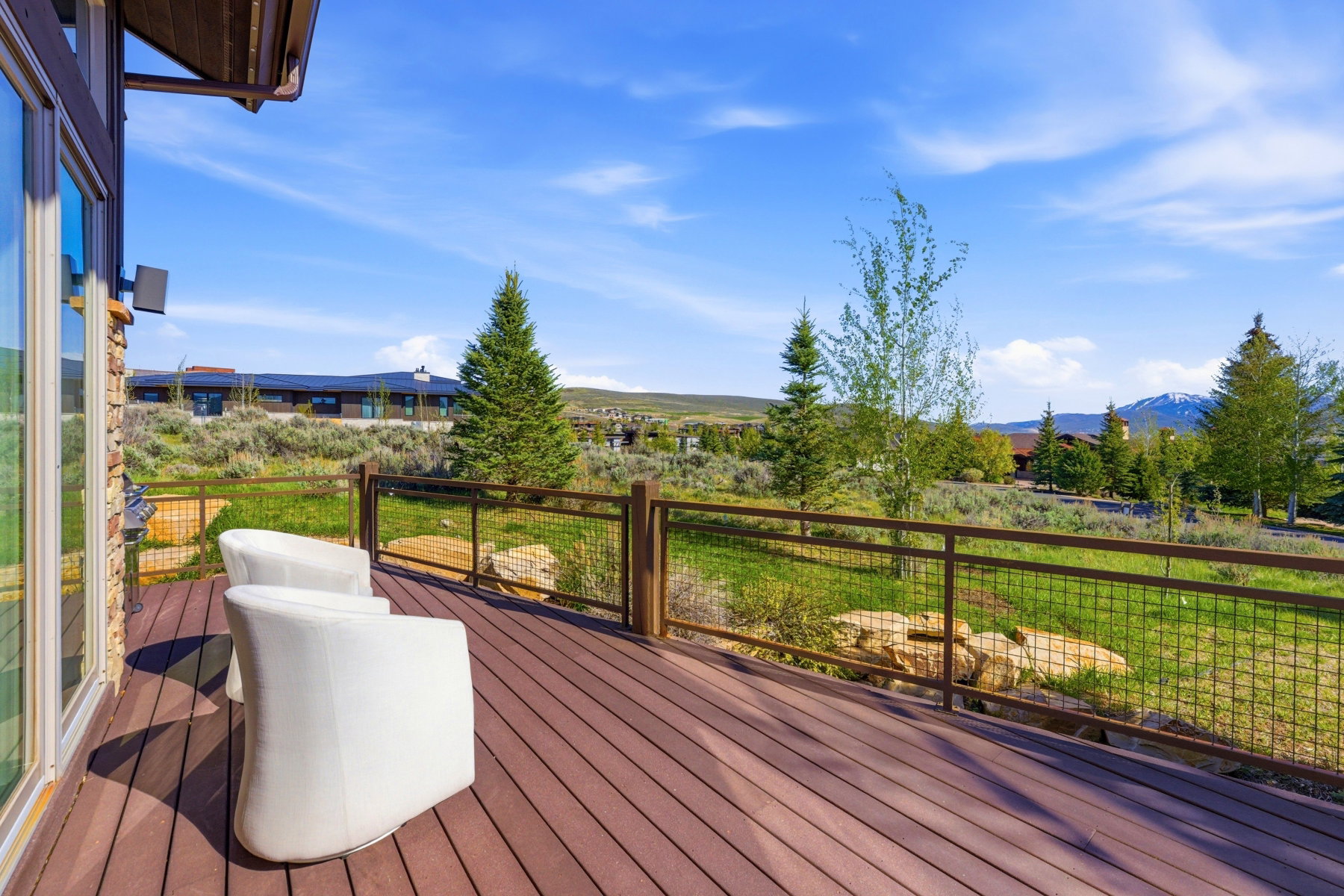 Spacious outdoor deck featuring wood-finish decking and a metal grid railing