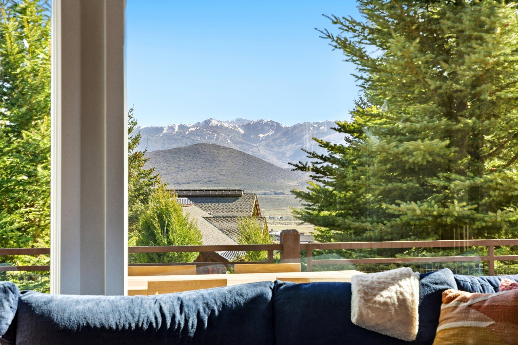 Expansive mountain scenery framed by large windows and evergreen trees