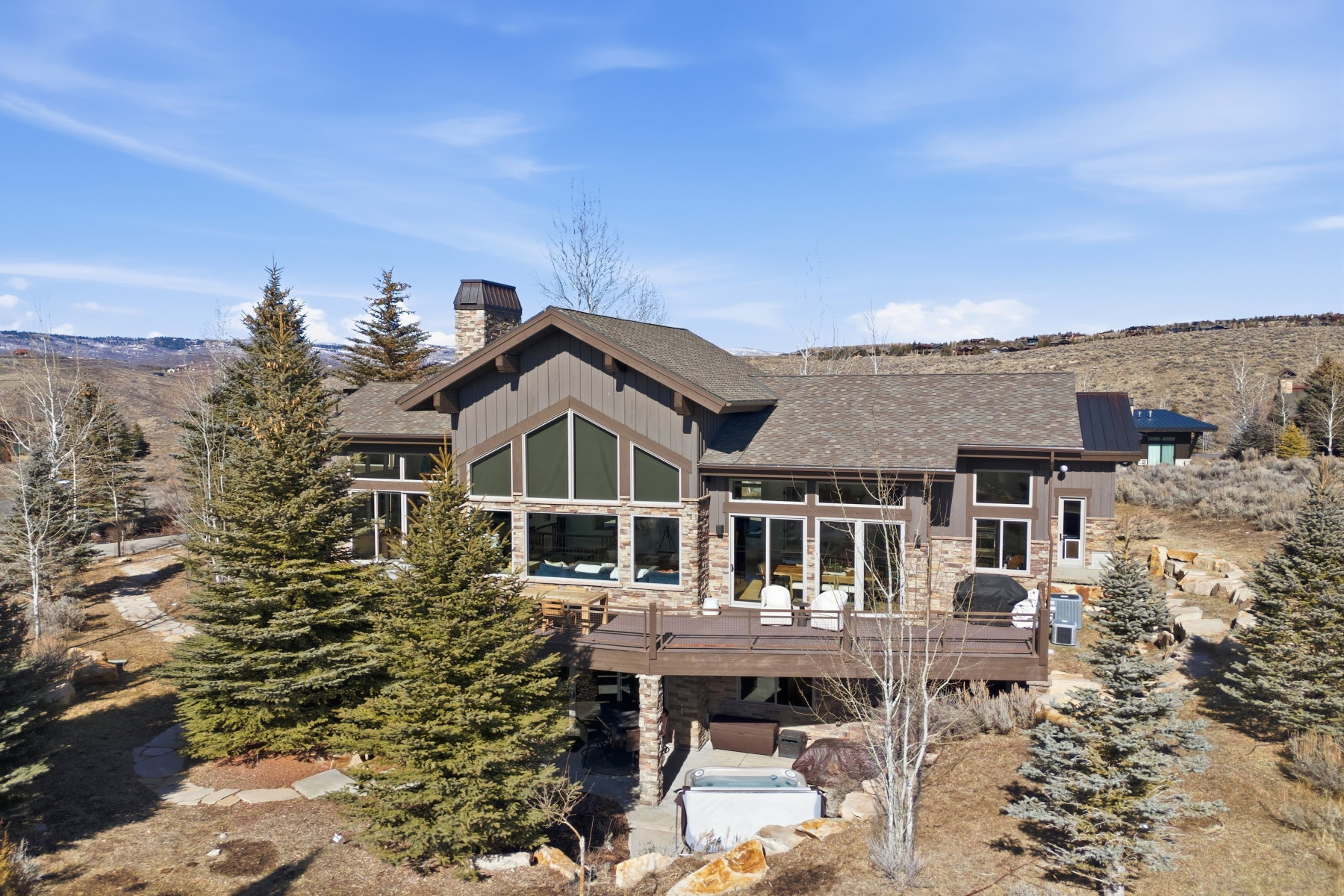 Rustic-inspired architecture featuring stone accents and vertical wood siding