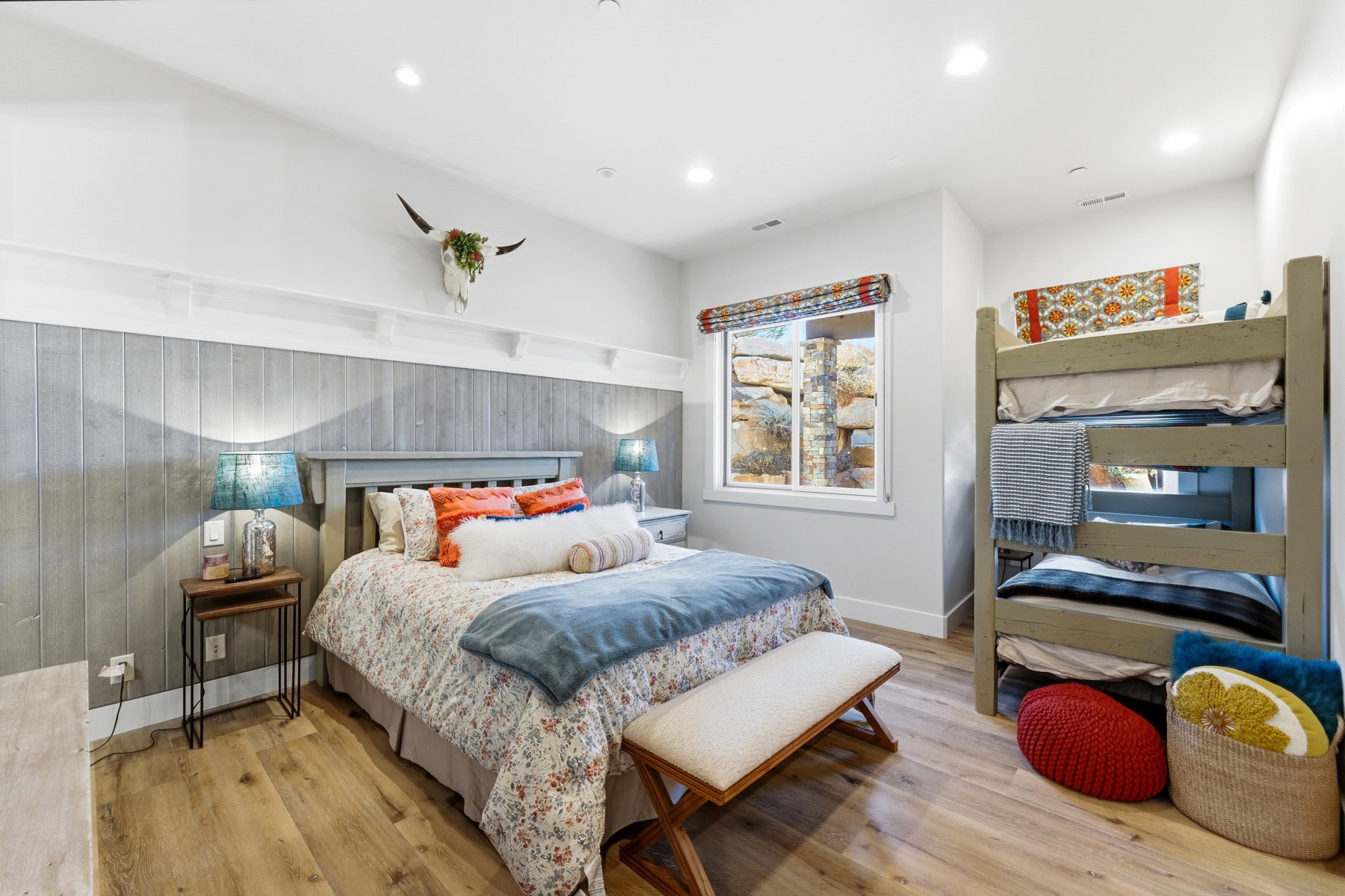 Spacious room featuring wood-finish flooring, a fixed window with a decorative shade, and recessed lighting