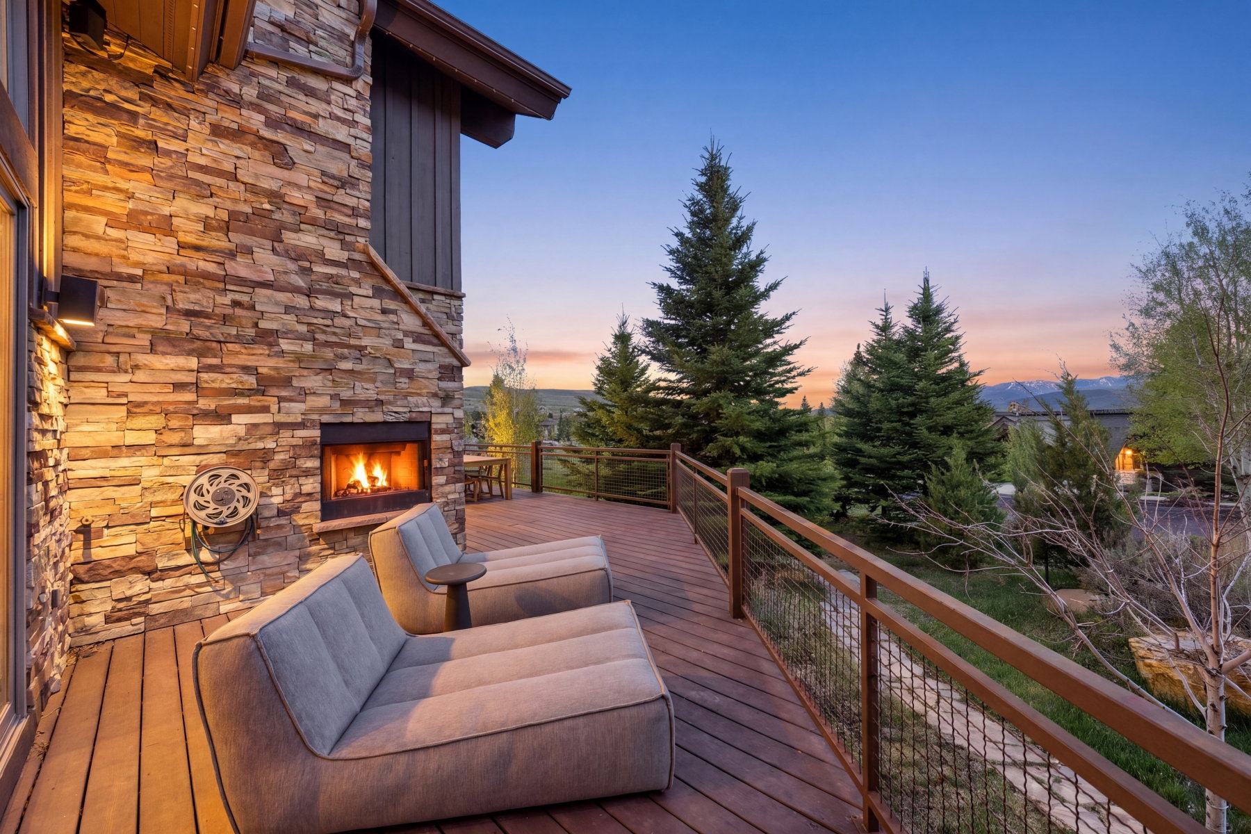 Expansive wood-finish deck with a stone-clad fireplace and integrated lighting
