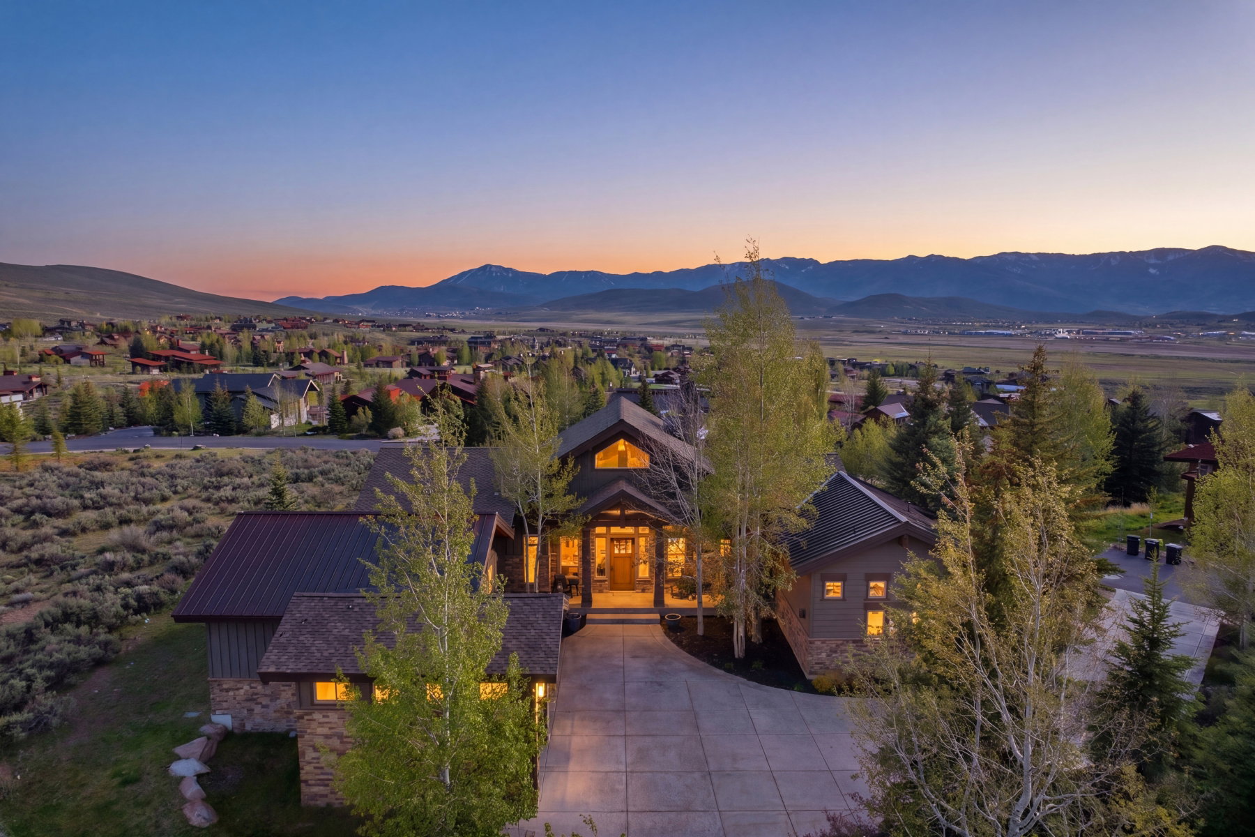 Mountain-style residence featuring a prominent gabled entrance, stone accents, and a metal roof