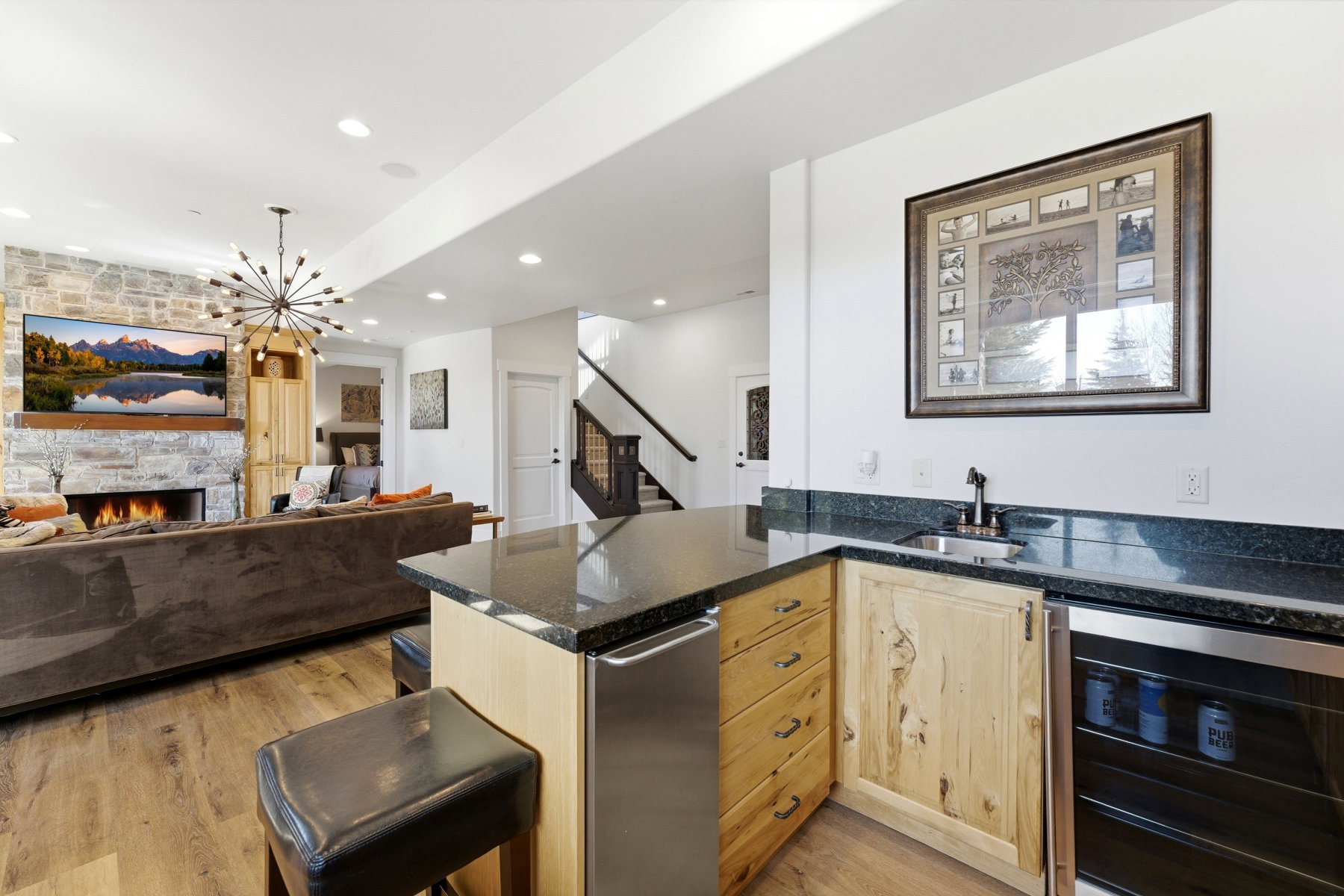 Entertainment area featuring a wet bar with dark countertops, a built-in mini-refrigerator, and wood-finish cabinetry