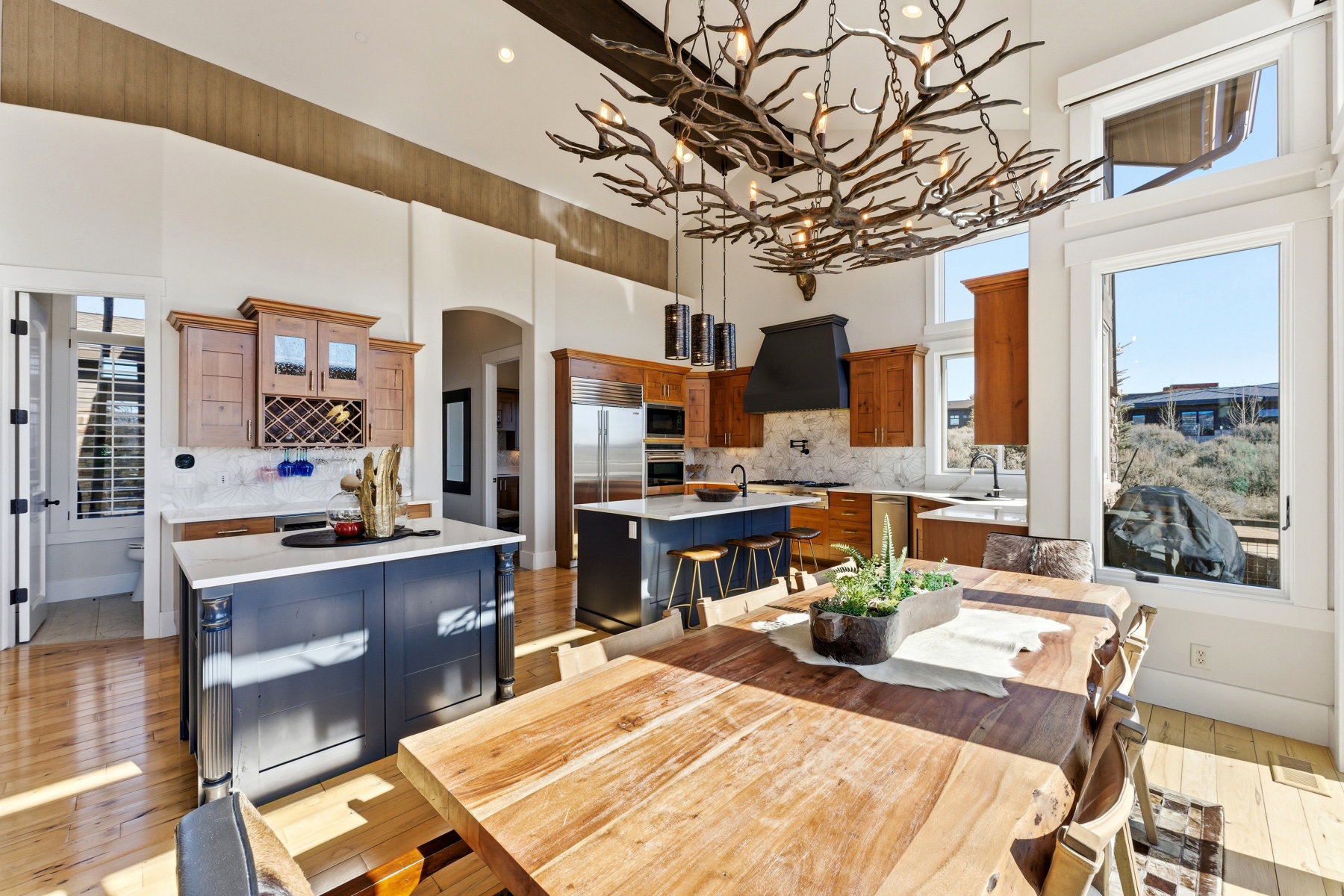Open-concept kitchen and dining area featuring a custom branch chandelier