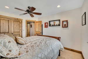 Carpeted bedroom featuring a ceiling fan, a closet, and recessed lighting