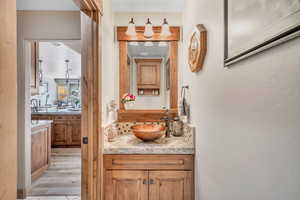 Bathroom featuring vanity, decorative backsplash, and light wood finished floors