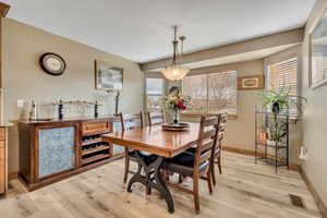 Dining room with light wood-type flooring and baseboards