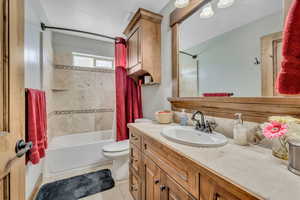 Bathroom with vanity, shower / tub combo with curtain, and light tile patterned floors
