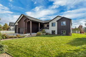 Back of property featuring driveway, a patio area, and an attached garage