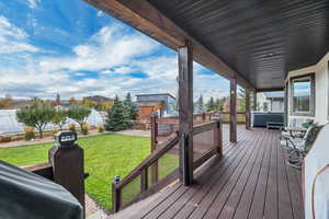 Wooden deck featuring a hot tub and a residential view
