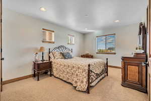 Bedroom with recessed lighting and light carpet