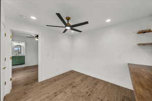 Spare room with wood finished floors, ceiling fan, and recessed lighting