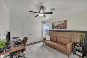 Carpeted office space featuring a ceiling fan