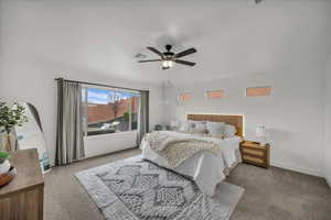 Carpeted bedroom with ceiling fan and baseboards