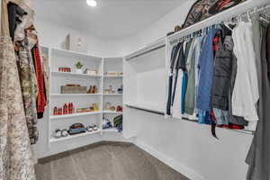 Walk in closet featuring light colored carpet