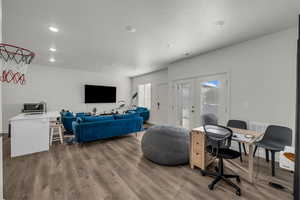 Living room with french doors, light wood-style flooring, recessed lighting, and an office area