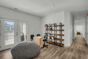 Home office featuring light wood finished floors and french doors