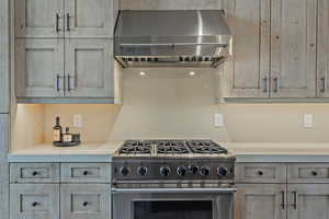 Kitchen featuring stainless steel range, extractor fan, and light wood finish cabinetry